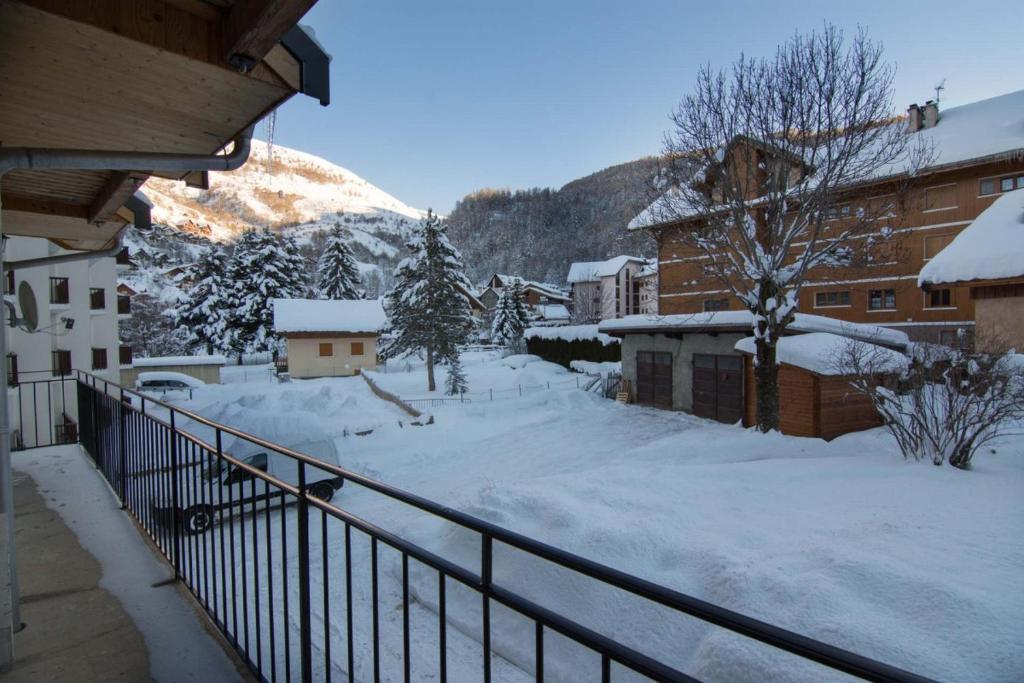 a snow covered street with buildings and a fence at Appartement - Les ecrins 3 in Valloire