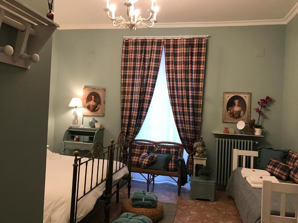 Schlafzimmer mit einem Bett und einem Fenster mit Vorhängen in der Unterkunft Dolce Farinella in Putignano