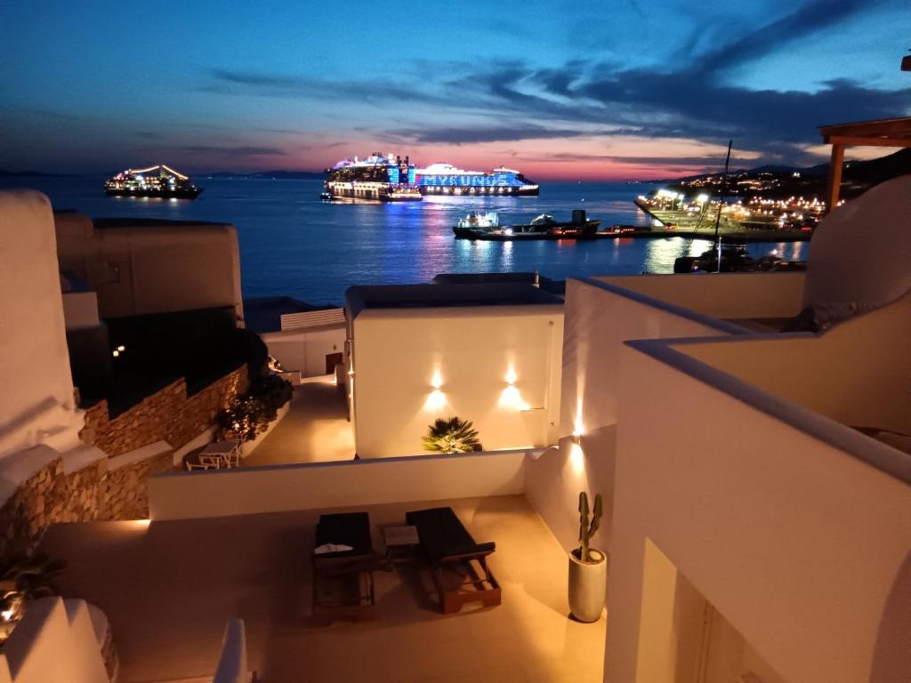 a balcony with a view of the ocean at night at Avra Luxury Suites Mykonos in Tourlos