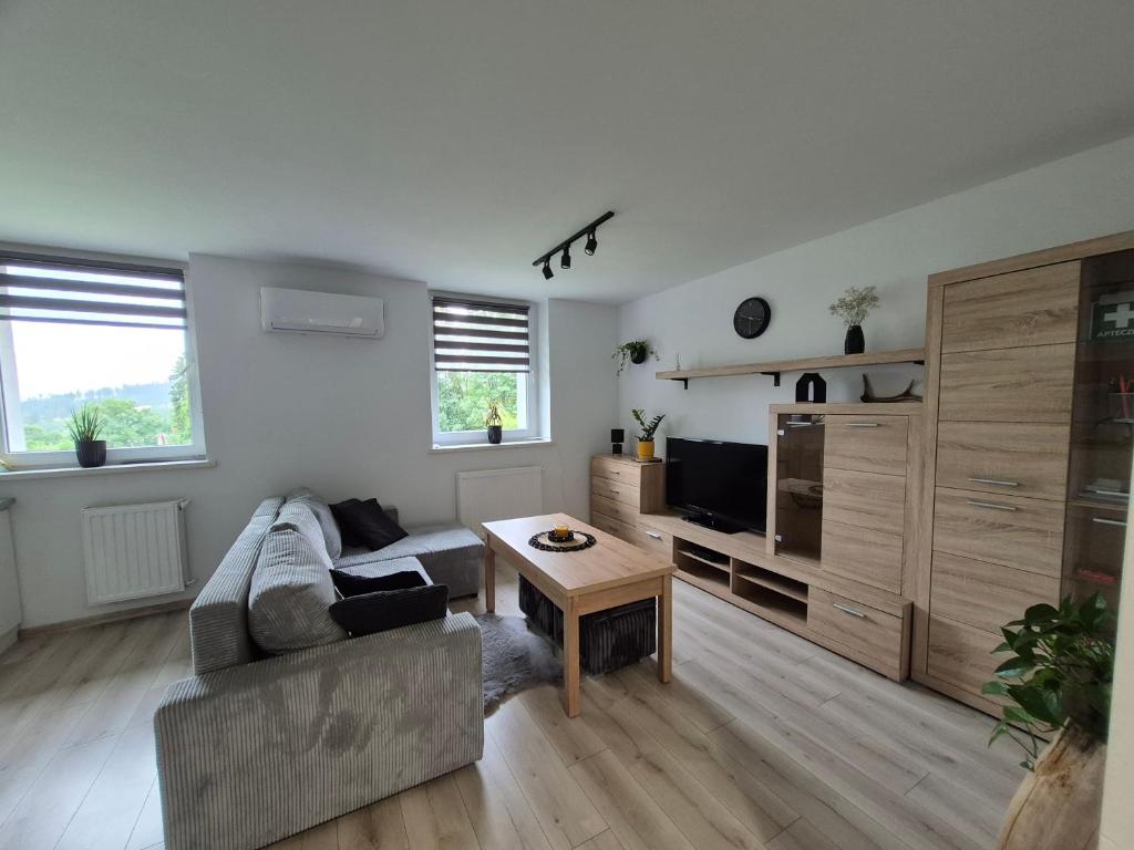 a living room with a couch and a table at Sowi Zakątek in Jugów