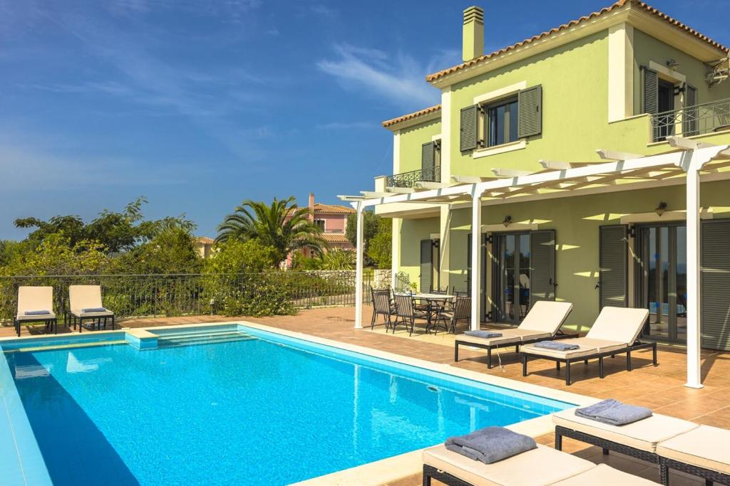 a villa with a swimming pool in front of a house at Villa Dora in Kefallonia