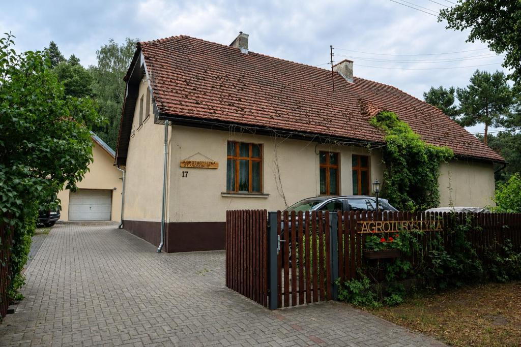 a small white house with a fence and a car at Agroturystyka Staroscin in Rzepin