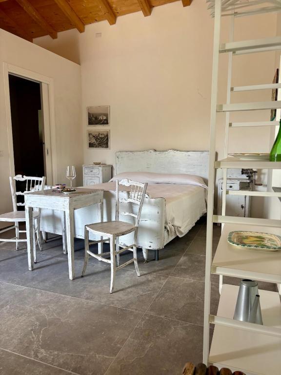 a room with a bed and a table and chairs at EtnaDetox Vineyard Open Space in Castiglione di Sicilia