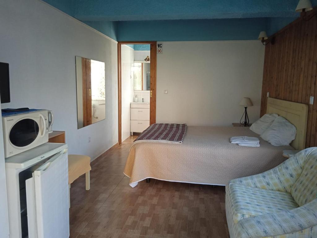 a small bedroom with a bed and a couch at Casinhas do Ribeiro in Póvoa de Lanhoso
