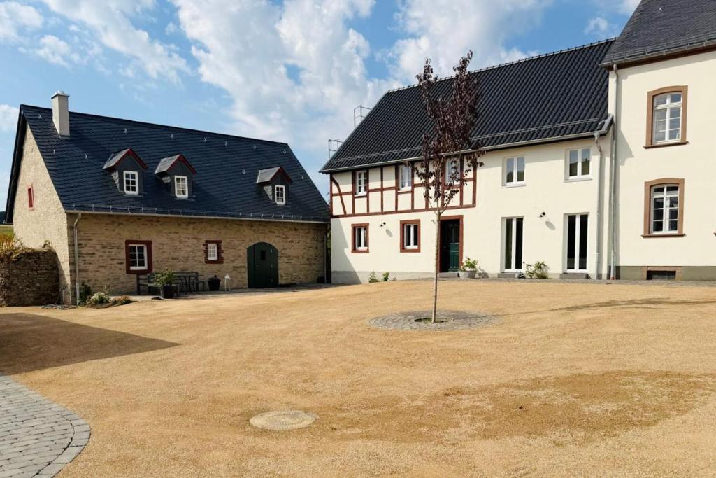 a large white building with a tree in the middle at Hollender Hof in Bongard