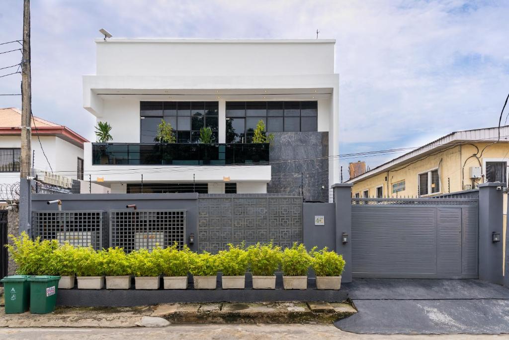 a white house with a fence in front of it at One90 Apartment in Lagos