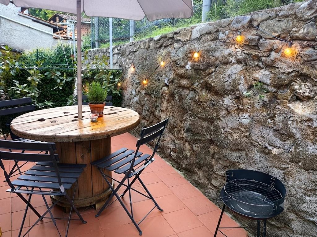 a wooden table with chairs and an umbrella on a patio at La Voltina in Diecimo