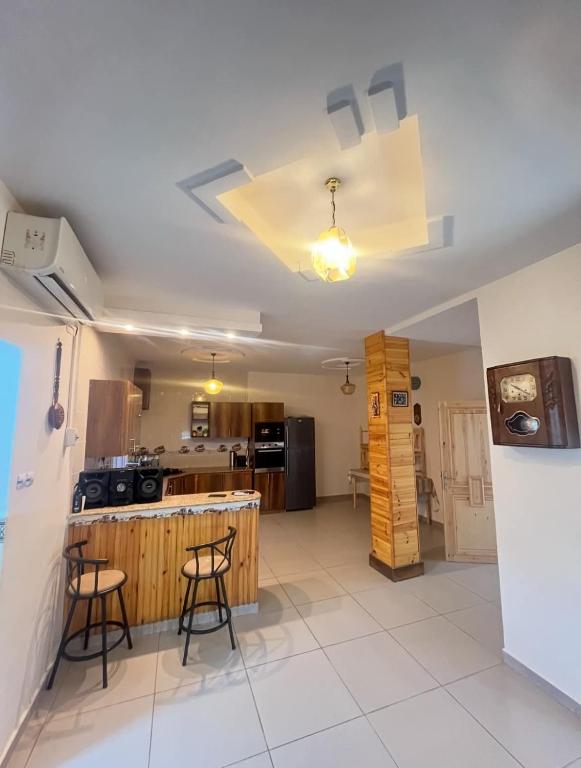 a kitchen with a table and chairs in a room at HÉBERGEMENT Sahnoun in Mostaganem