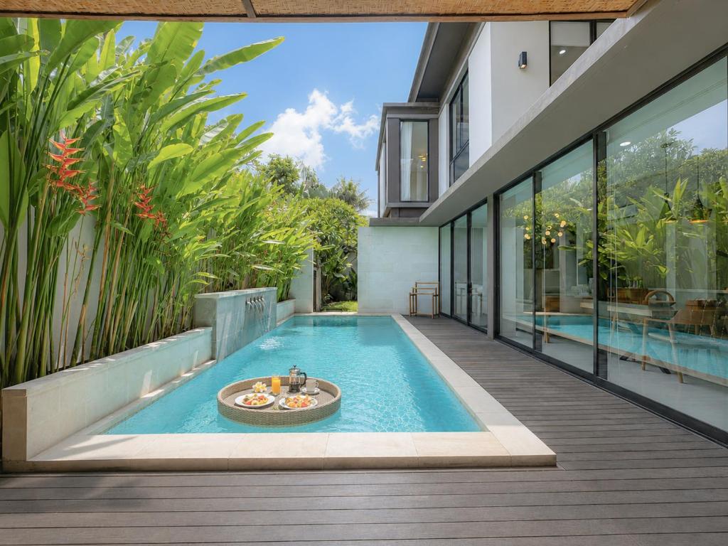 a swimming pool in the middle of a house at Tridi Beach Villa by Nagisa Bali in Tanah Lot