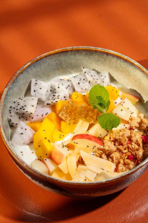 A fruit-and-granola bowl with dragon fruit, mango, apple, citrus and honeycomb.