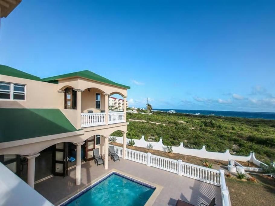 a view of a house with a swimming pool and the ocean at Ocean Gem Villa in The Valley