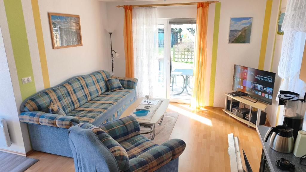 a living room with two couches and a television at Landidyll in Ummanz
