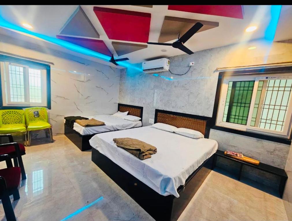 a room with two beds and a ceiling with blue lights at Global Stay Mantralayam in Mādhavaram
