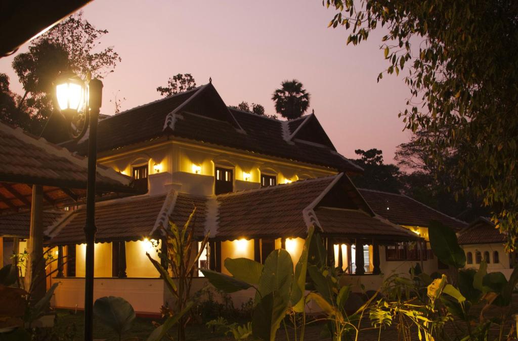 a house lit up at night with lights at Suryamangalam Heritage in Cheruppulasseri