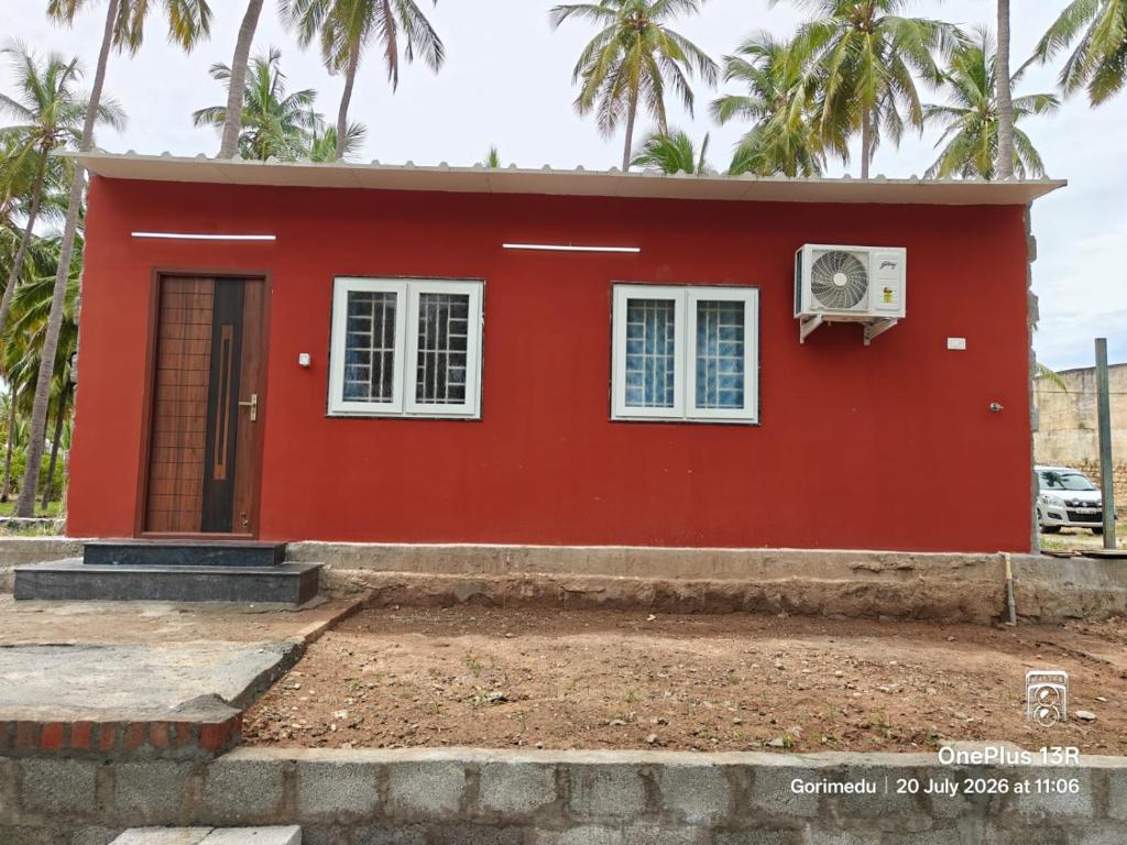 a red house with a white window at Coco Kudil - FARM STAY in Salem