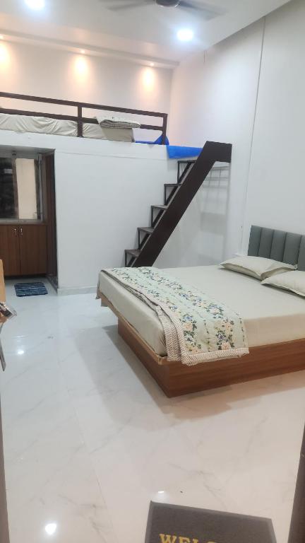 a bed sitting in a room with a staircase at Raya Inn in Pandharpur