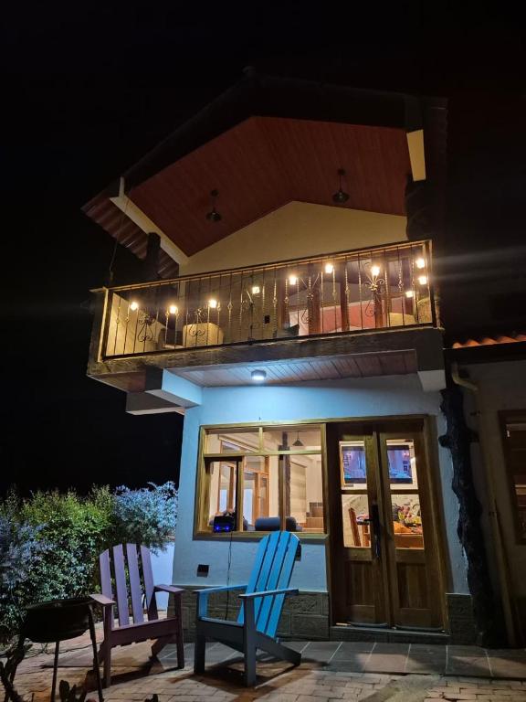 a house with a balcony with two chairs and a table at Tinny House Villa Victoria in Tinjacá