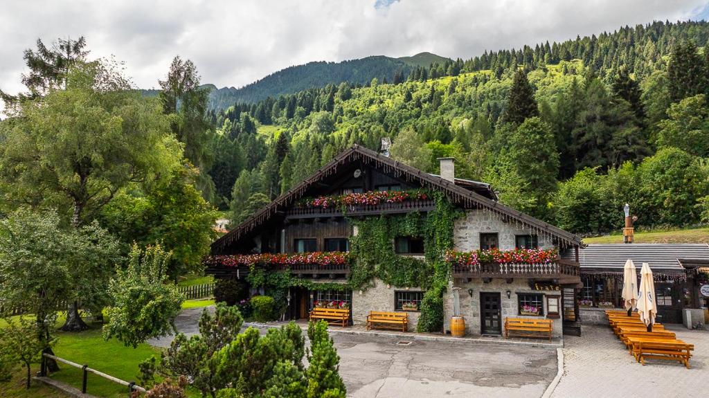 a building with flowers on the side of it at Locanda dal Giulio al Fratè B&B in Madonna di Campiglio
