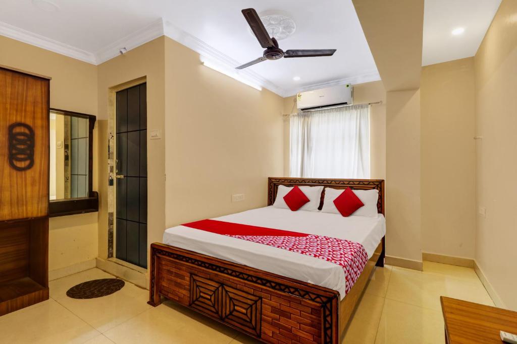 a bedroom with a bed and a ceiling fan at Hotel O RD CONVENTIONS in Visakhapatnam