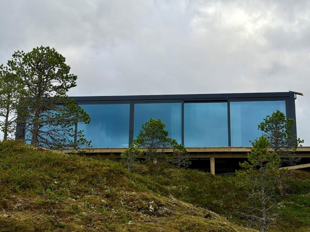 a glass house on top of a hill at Brennvika Panorama in Hamarøya