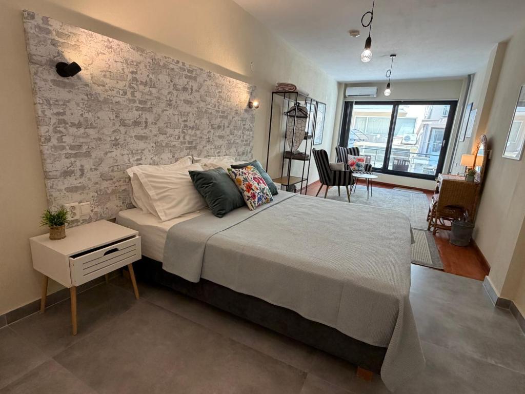 a bedroom with a large bed and a brick wall at 11 Diamond Drive, Luxury Bright & Quiet City Center Loft, Easy Access in Kavála