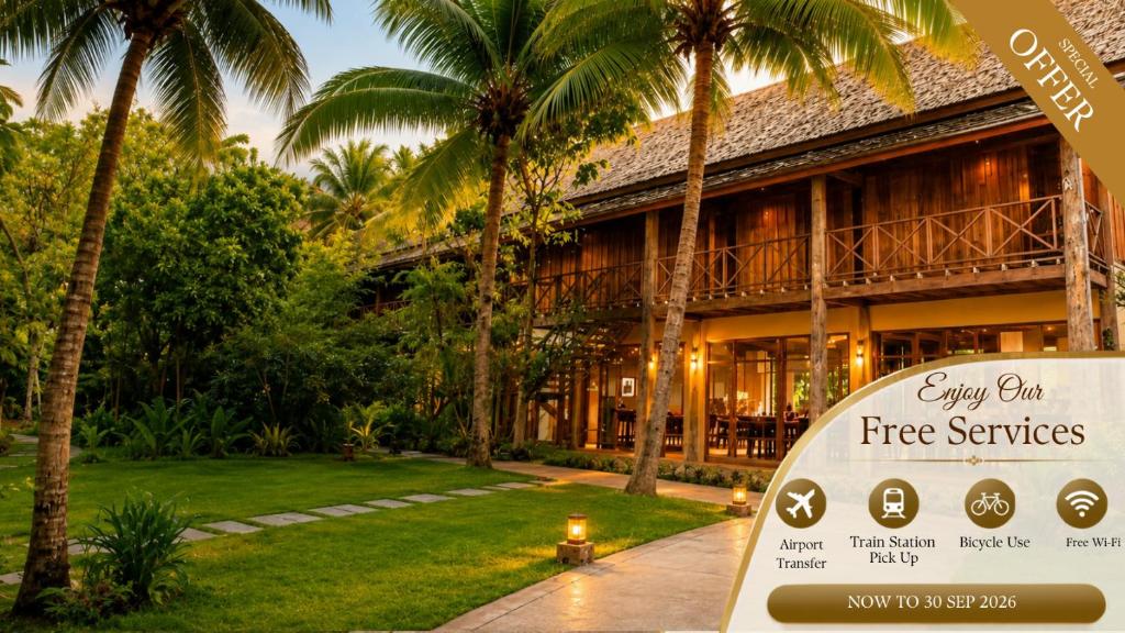 a sign in front of a building with palm trees at My Dream Boutique Resort in Luang Prabang