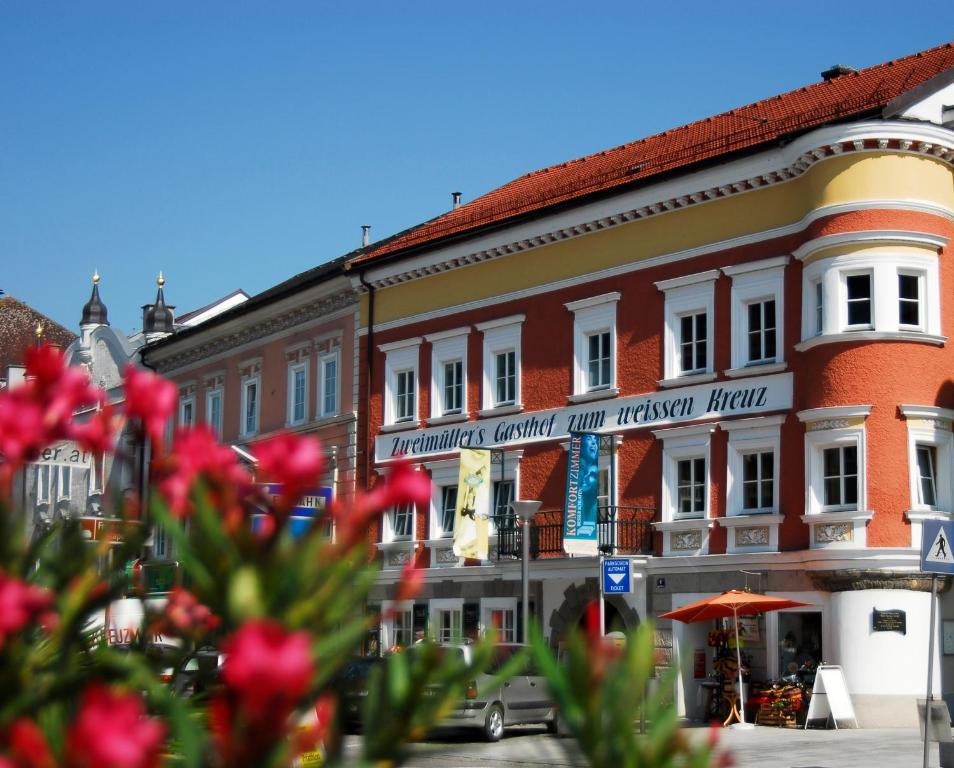 a group of buildings on a street with red flowers at Gasthof Hotel Zweimüller in Grieskirchen