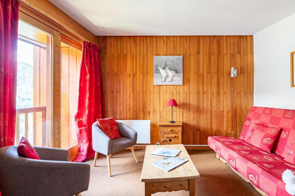 a living room with a couch and a table at Large Méribel Three Valleys in Les Allues