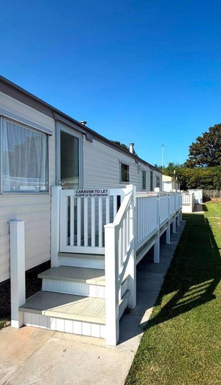 a mobile home with a porch and a white railing at Skegness Seaside Escape in Ingoldmells