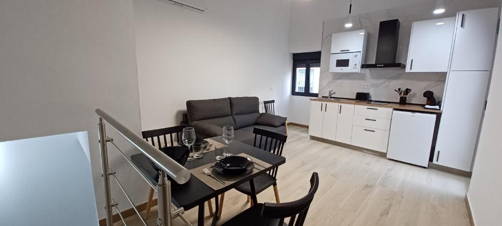 a kitchen and a living room with a table and chairs at Apartamento Turístico La Miranda in Elche de la Sierra