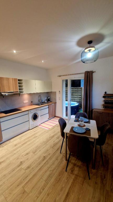 a living room with a table and a kitchen at Studio cosy avec jacuzzi , sauna et salle de sport in Vallauris