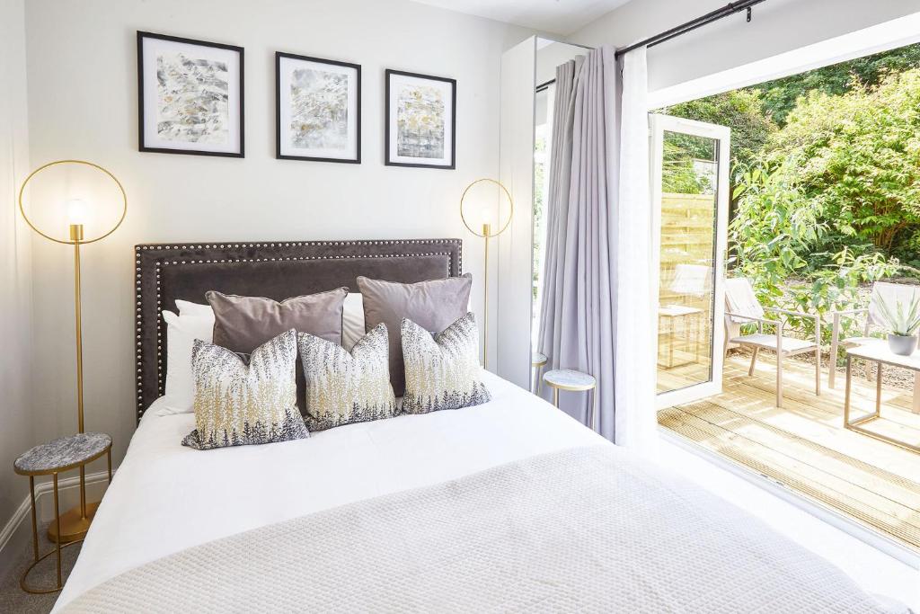 a bedroom with a white bed and a balcony at The Madison Garden in Whitby