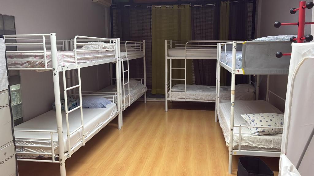 three bunk beds in a room with wooden floors at Hostel da Maria - Porto in Vila Nova de Gaia