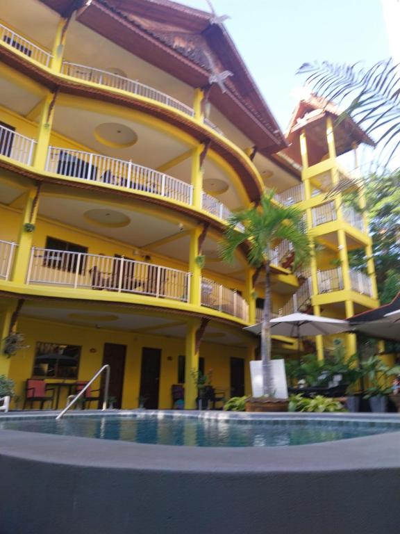 a hotel with a pool in front of a building at Phratamnak Inn Hotel & Guesthouse - 100 mtr from the beach in Pattaya South