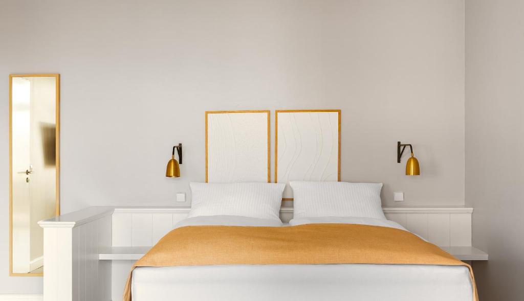 a white bedroom with a large bed with white walls at Limehome Berlin Chausseestraße in Berlin