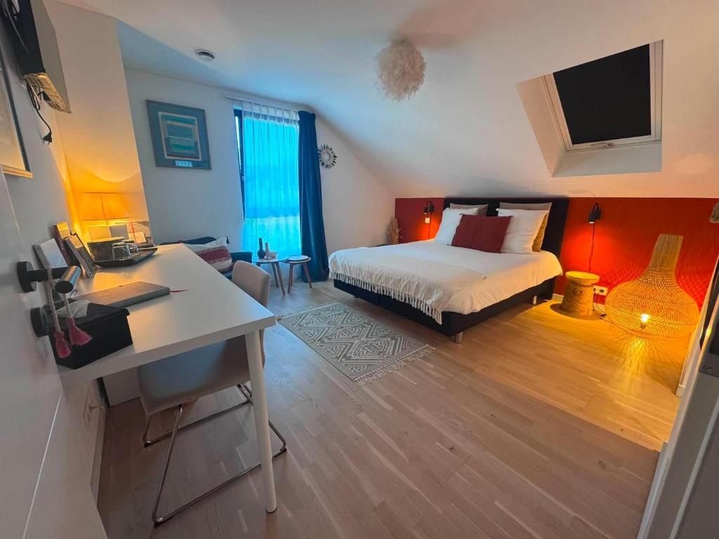 a bedroom with a bed and a desk with a computer at La Pacha, chambre d'hôtes in Spa