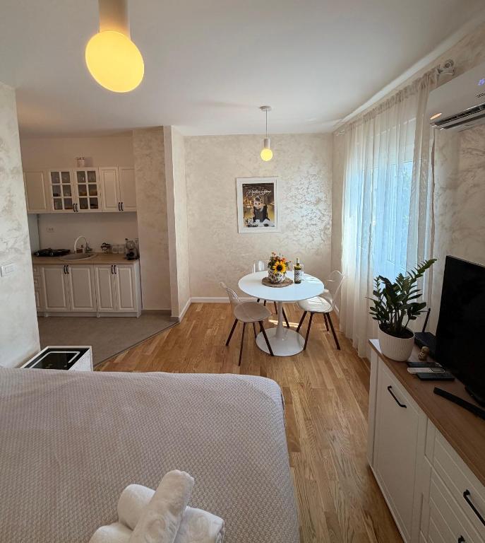 a living room with a table and a kitchen at Tiffany apartment - Podgorica in Podgorica