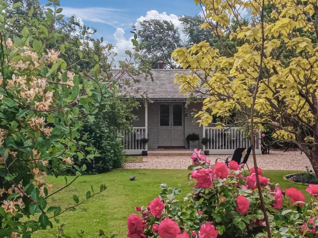 a house with a garden with pink flowers at The Pavilion in Swaton