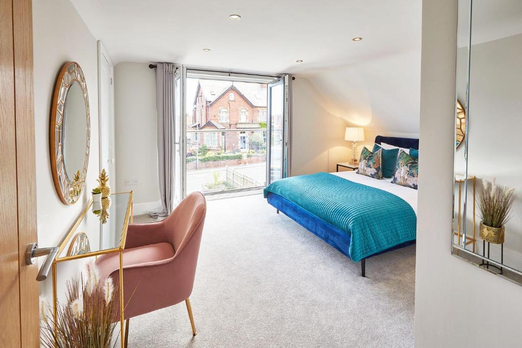 a bedroom with a bed and a mirror and a chair at The Penthouse Retreat in Whitby