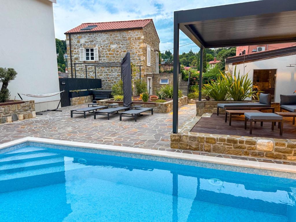 a swimming pool with a patio and a house at Gloria Holiday - Villa di Istria in Piran