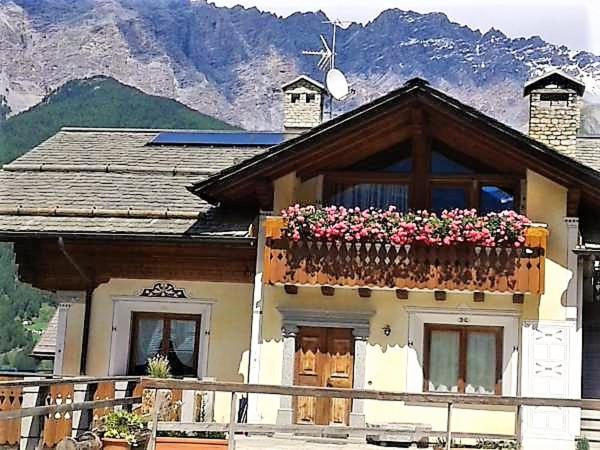 uma casa com uma varanda com flores em Il Balcone Delle Alpi em Bormio