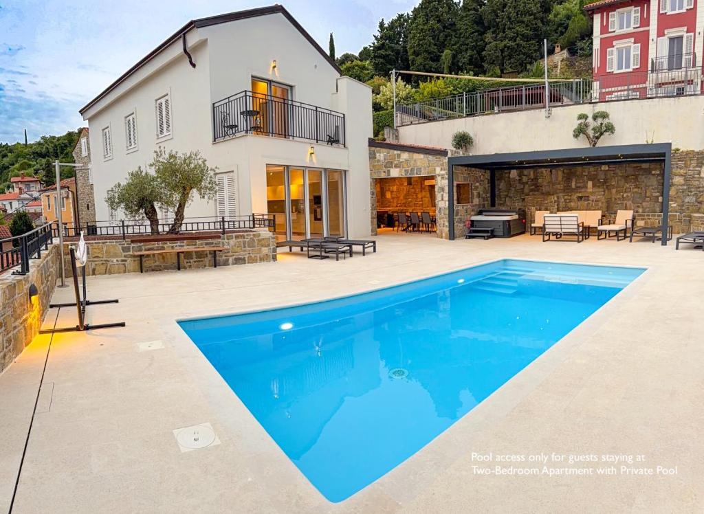 a swimming pool in front of a house at Gloria Holiday - Casa Bianca in Piran