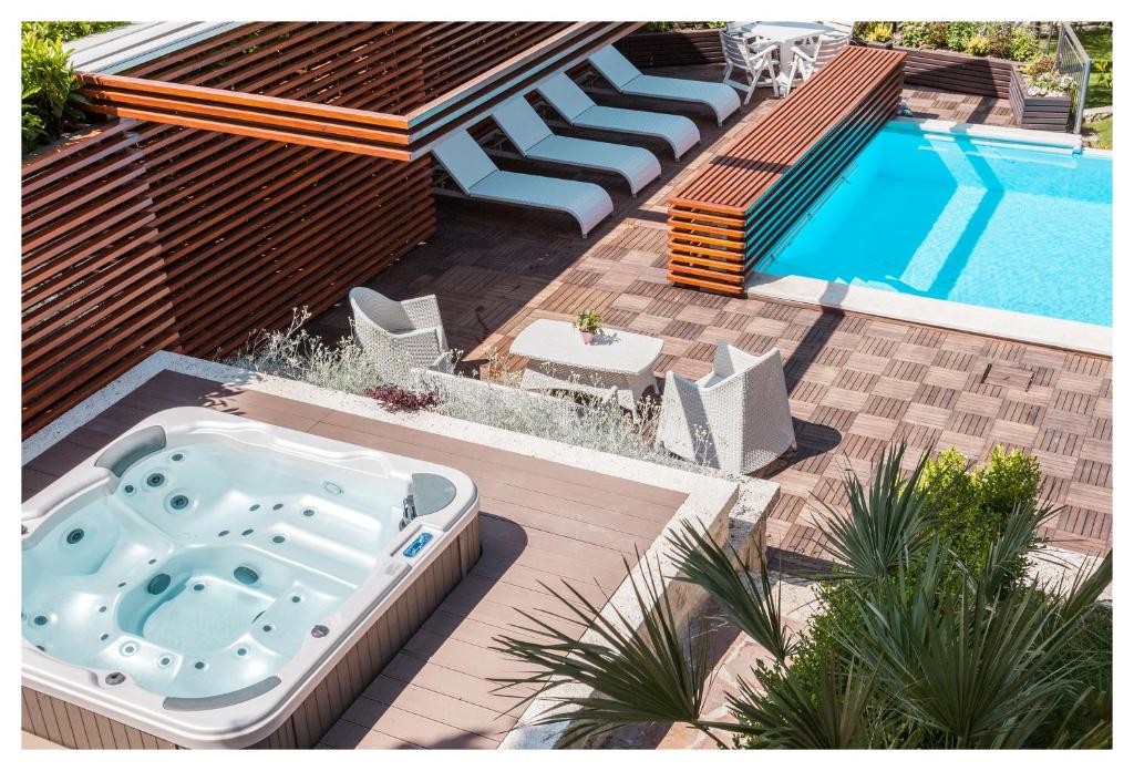 a hot tub on a deck next to a swimming pool at Fontana Vecchia in Atina