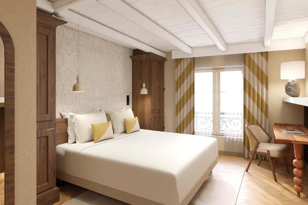 a bedroom with a large white bed and a desk at Hôtel de l'Europe by HappyCulture in Strasbourg