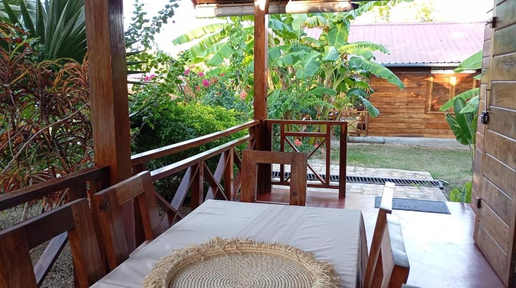 a patio with a table and chairs on a porch at Chalet Bois Luxe in Nosy Be