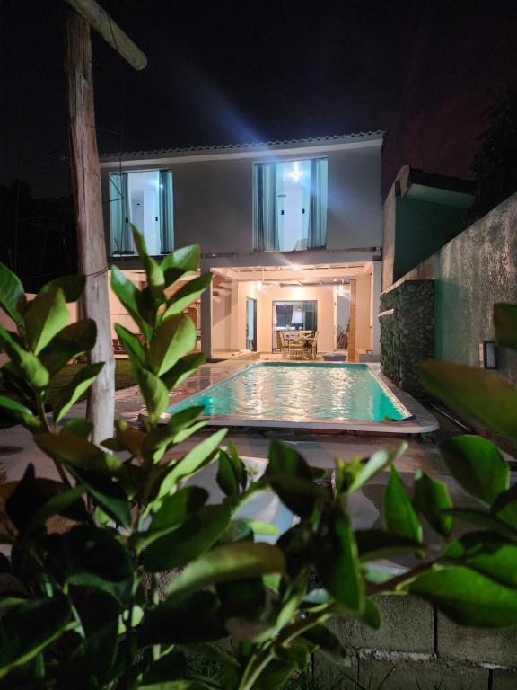 a house with a swimming pool at night at Casa Casal Itapoá in Itapoa