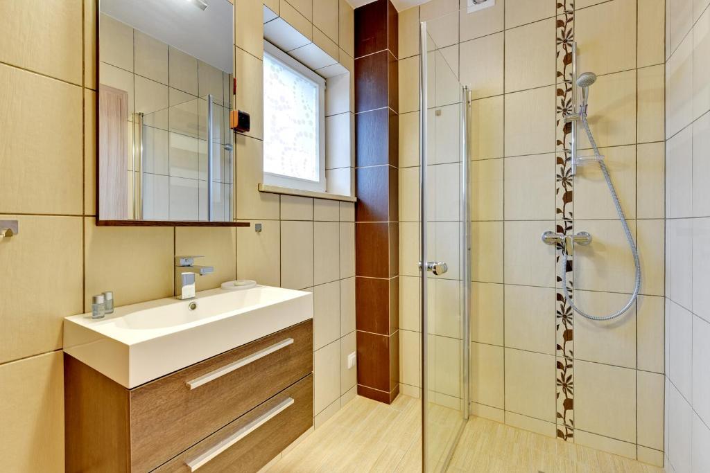 a bathroom with a sink and a shower at Villa Arkodes in Gdańsk