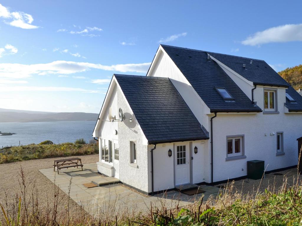 a white house with a view of the water at Lily Lodge - Uk31958 in Dibaig