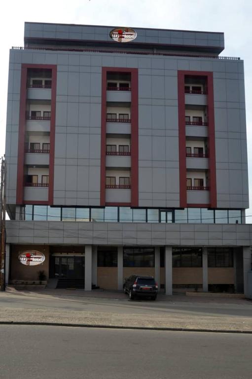 a large building with a car parked in front of it at ALVI SEVEN Hotel in Douala