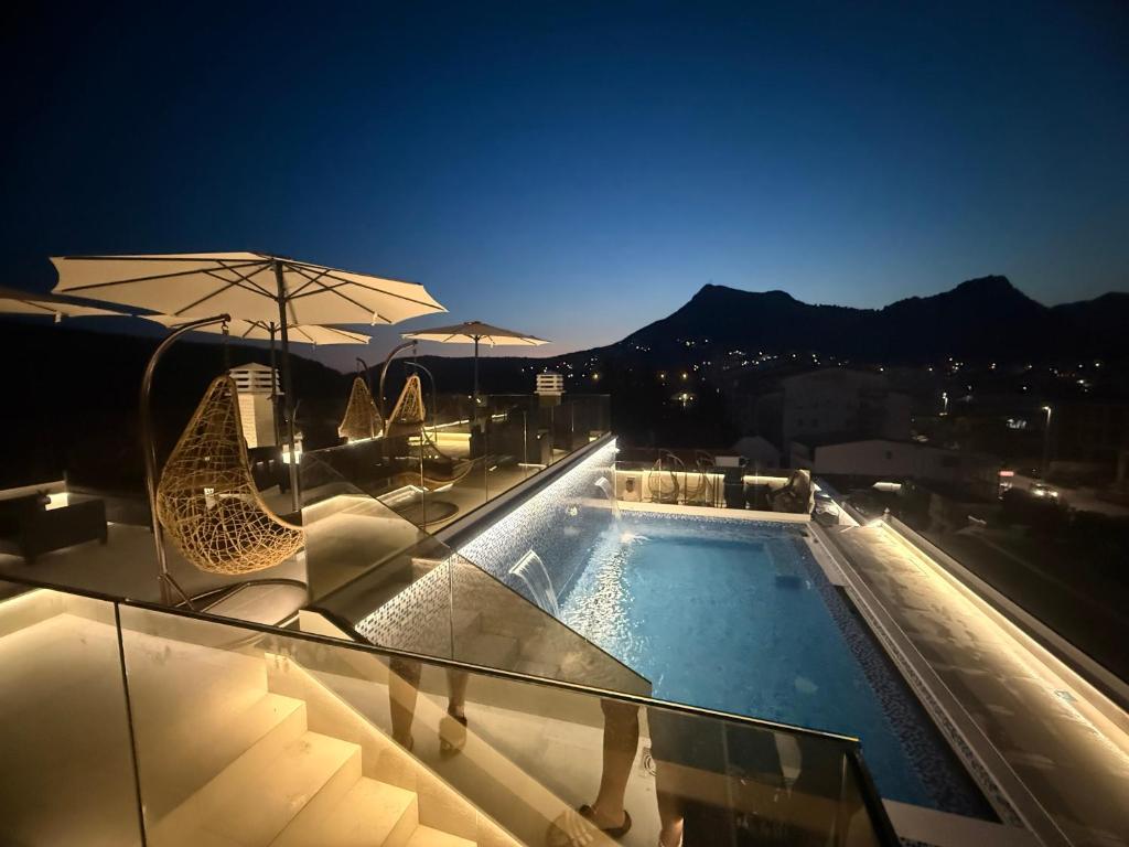 a swimming pool on top of a building at night at Apartments Pericic LUX in Sutomore